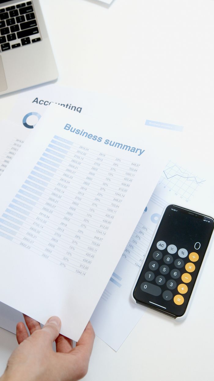 Business summary sheet with a calculator on a desk for financial analysis.